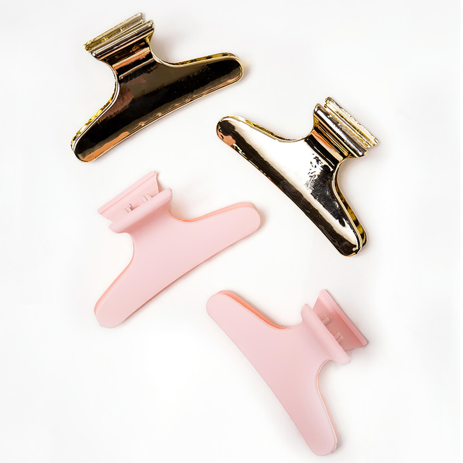 Four hair section clips in a mix of metallic gold and soft pink colors, featuring a sturdy design with a wide opening for secure grip.