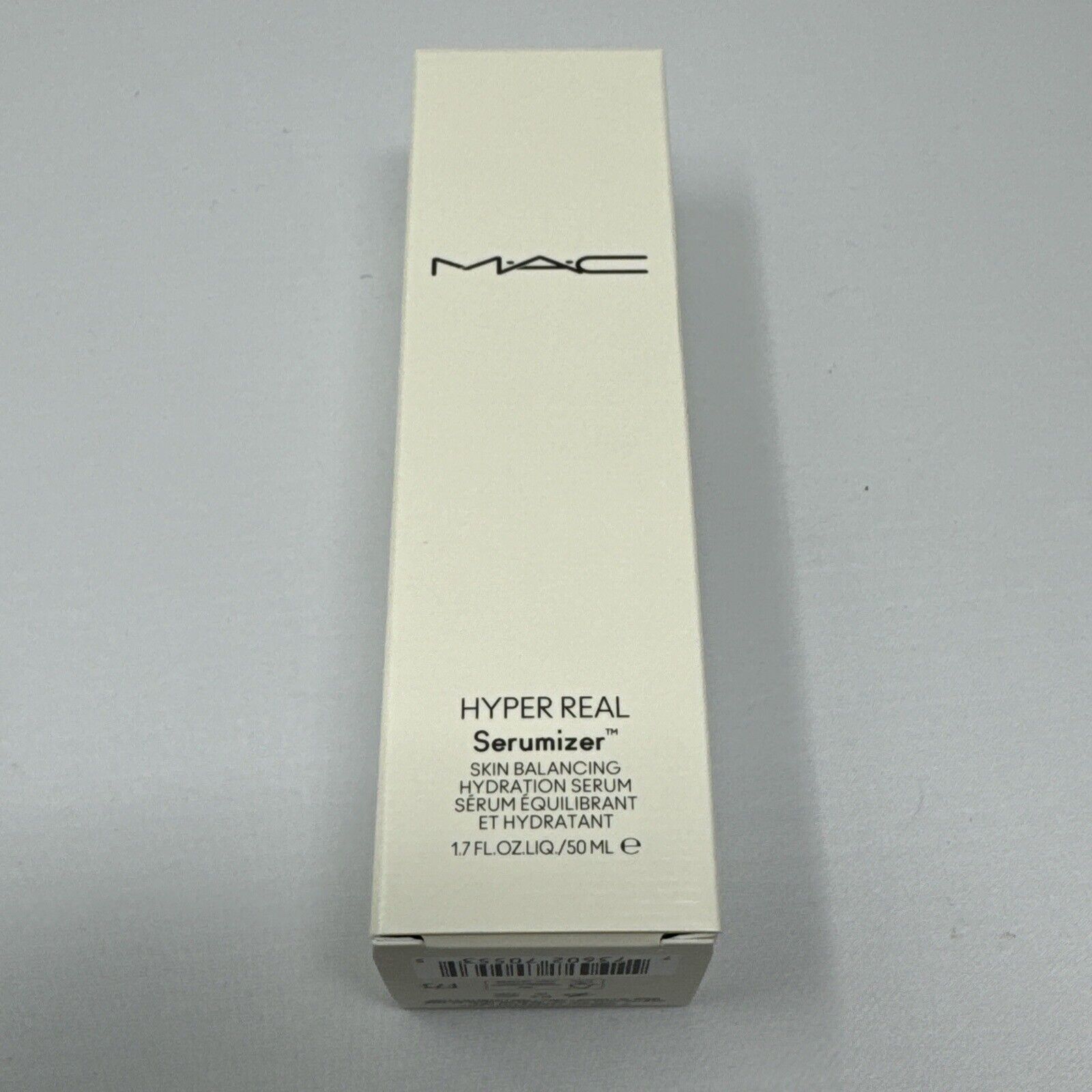 White box with sleek design featuring "MAC" logo, "HYPER REAL Serumizer" text, and product details in black, showcasing a modern and elegant packaging style.