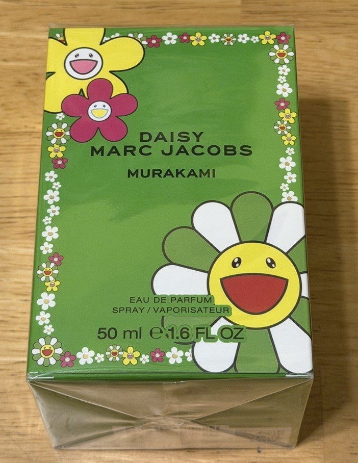Bright green box featuring playful flower designs with smiling faces, labeled "Marc Jacobs Daisy Murakami," containing 50ml of Eau De Parfum.