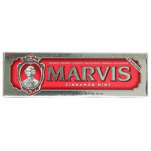Marvis Cinnamon Mint Toothpaste in a shiny silver and red tube, featuring ornate lettering and a vintage portrait on the front, with 85ml of product visible.