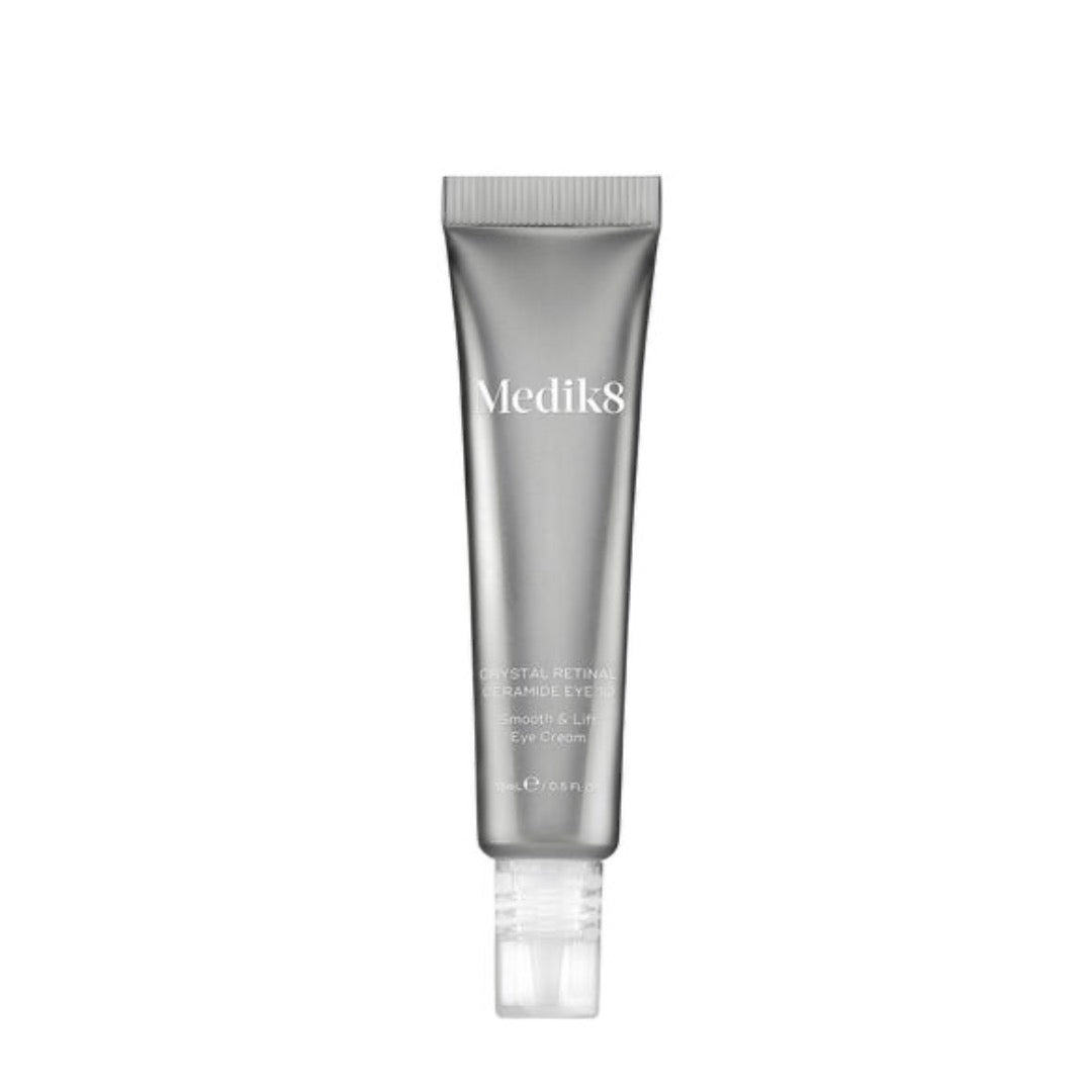 Silver tube of Medik8 Crystal Retinal Ceramide Eye cream, featuring a clear applicator tip and sleek design, labeled with the product name and details in white text.