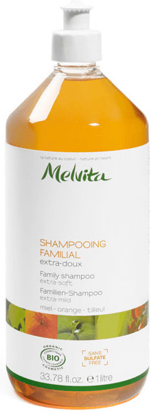 Clear plastic bottle of Melvita Extra Gentle Family Shampoo, 33.8 oz, featuring a white pump top and a light orange liquid, with floral and leaf designs on the label.