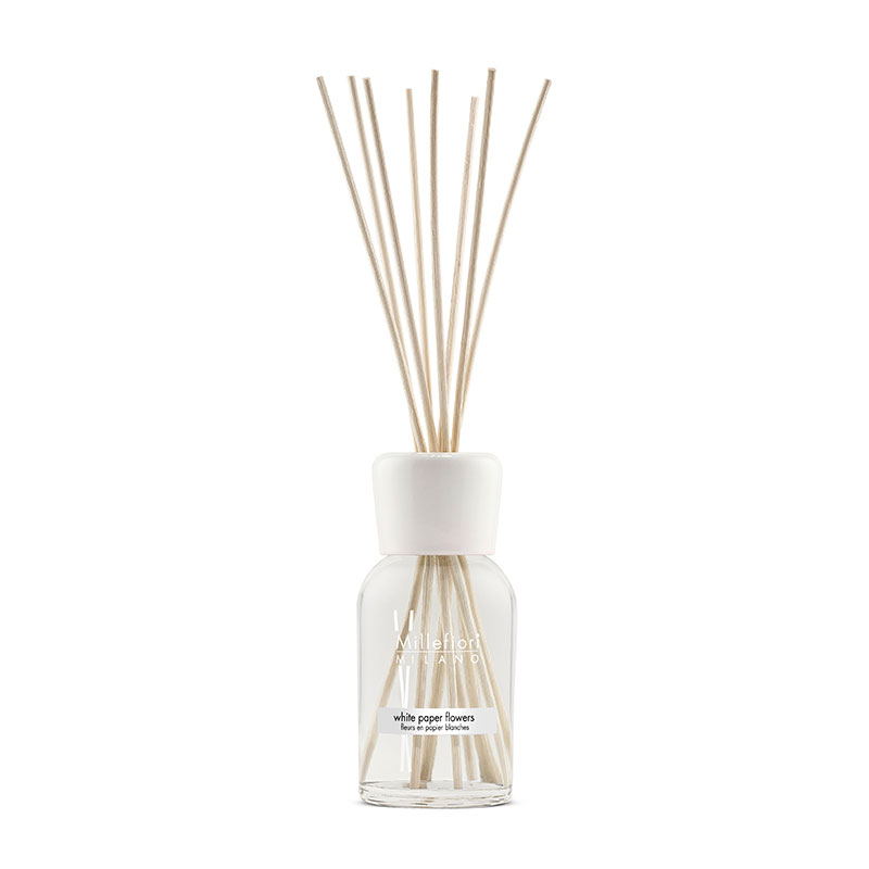 Clear glass diffuser bottle with a white cap, featuring white paper flower accents and several wooden reeds, containing 250ml of natural fragrance.