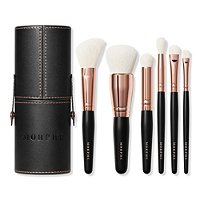 Morphe Rose Away Makeup Brush Set featuring six brushes with soft white bristles and rose gold ferrules, housed in a sleek black storage tub with embossed branding.