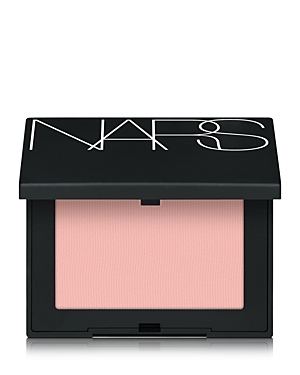 Nars New Blush in soft pink, housed in a sleek black compact with a glossy white logo, features a smooth powder texture ideal for adding a natural flush to the cheeks.
