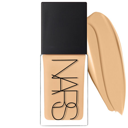 Nars Light Reflecting Foundation in Santafe, featuring a sleek glass bottle with a black cap, accompanied by a swatch of creamy beige foundation.