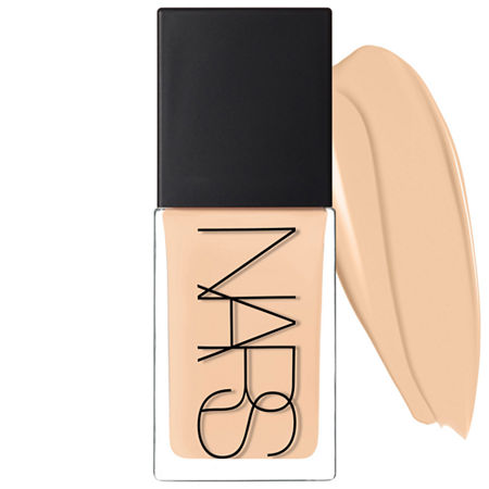 Nars Light Reflecting Foundation in Vienna, 30ml, features a clear glass bottle with a sleek black cap and a creamy beige swatch beside it, showcasing its smooth texture.
