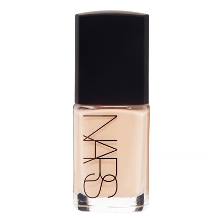 NARS Sheer Glow Foundation in a glass bottle with a black cap, featuring a light beige liquid inside and the NARS logo prominently displayed on the front.