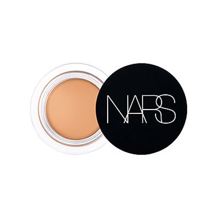 Nars Soft Matte Concealer in Ginger features a creamy, beige product in a clear jar with a sleek black lid displaying the Nars logo in white.