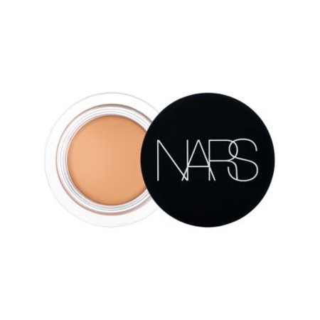 Nars Soft Matte Concealer in Vanilla features a round, black compact with a clear lid, showcasing a creamy, light beige concealer inside.