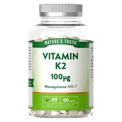 Clear plastic bottle containing 60 white tablets labeled "Vitamin K2 100µg" with green and white branding, featuring details about the product and its benefits.