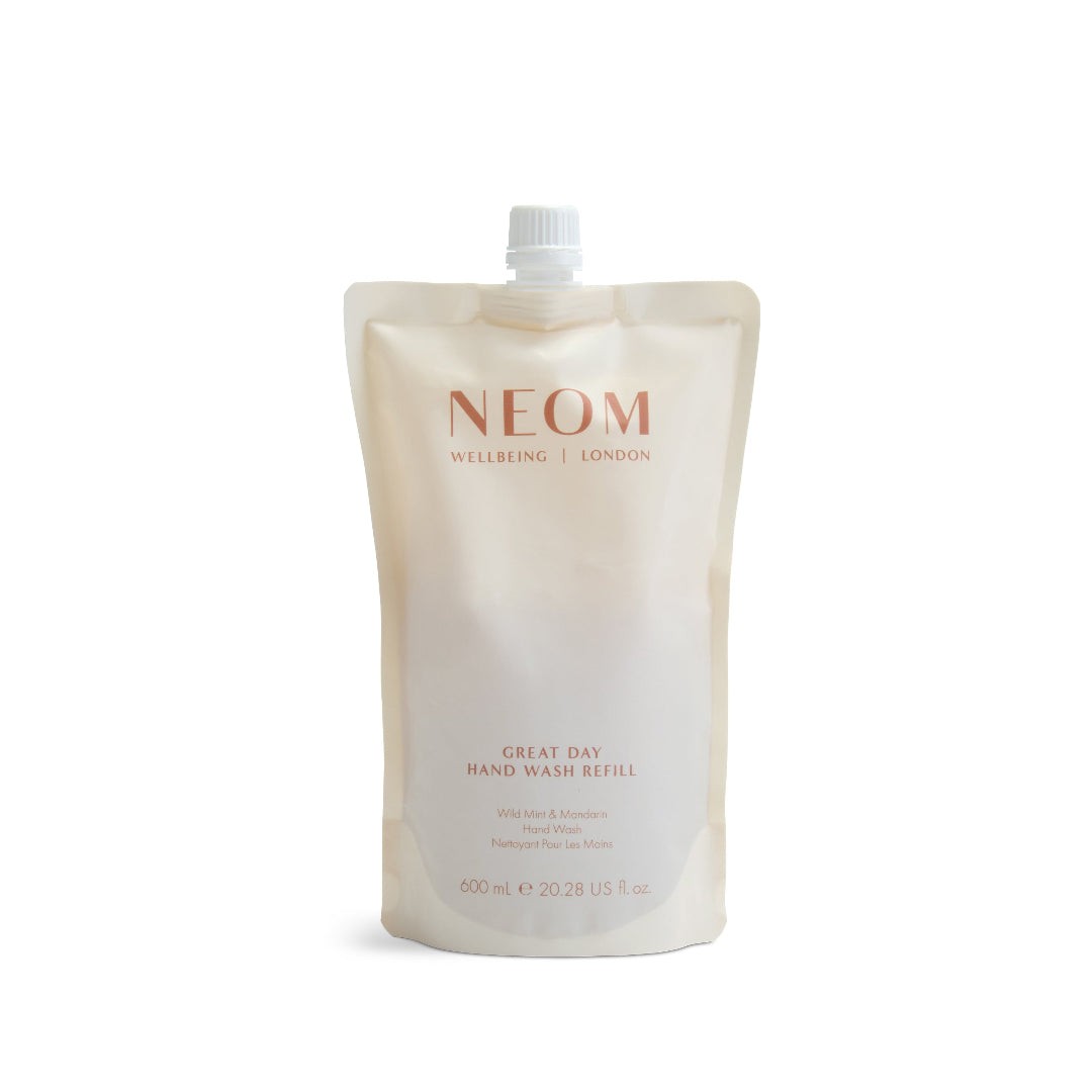 Cream-colored pouch with a white screw cap, labeled "NEOM WELLBEING LONDON," containing 600ml of Great Day Hand Wash refill, featuring a minimalist design and soft typography.