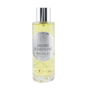 Clear glass bottle with a silver label reading "Jardins De Babylone Nicolai," containing a light yellow room spray, featuring a minimalist design and elegant typography.