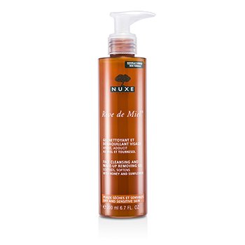 Clear plastic bottle with a pump dispenser, featuring a warm amber color, labeled "Rêve de Miel" in white text, highlighting its cleansing and makeup removing properties.