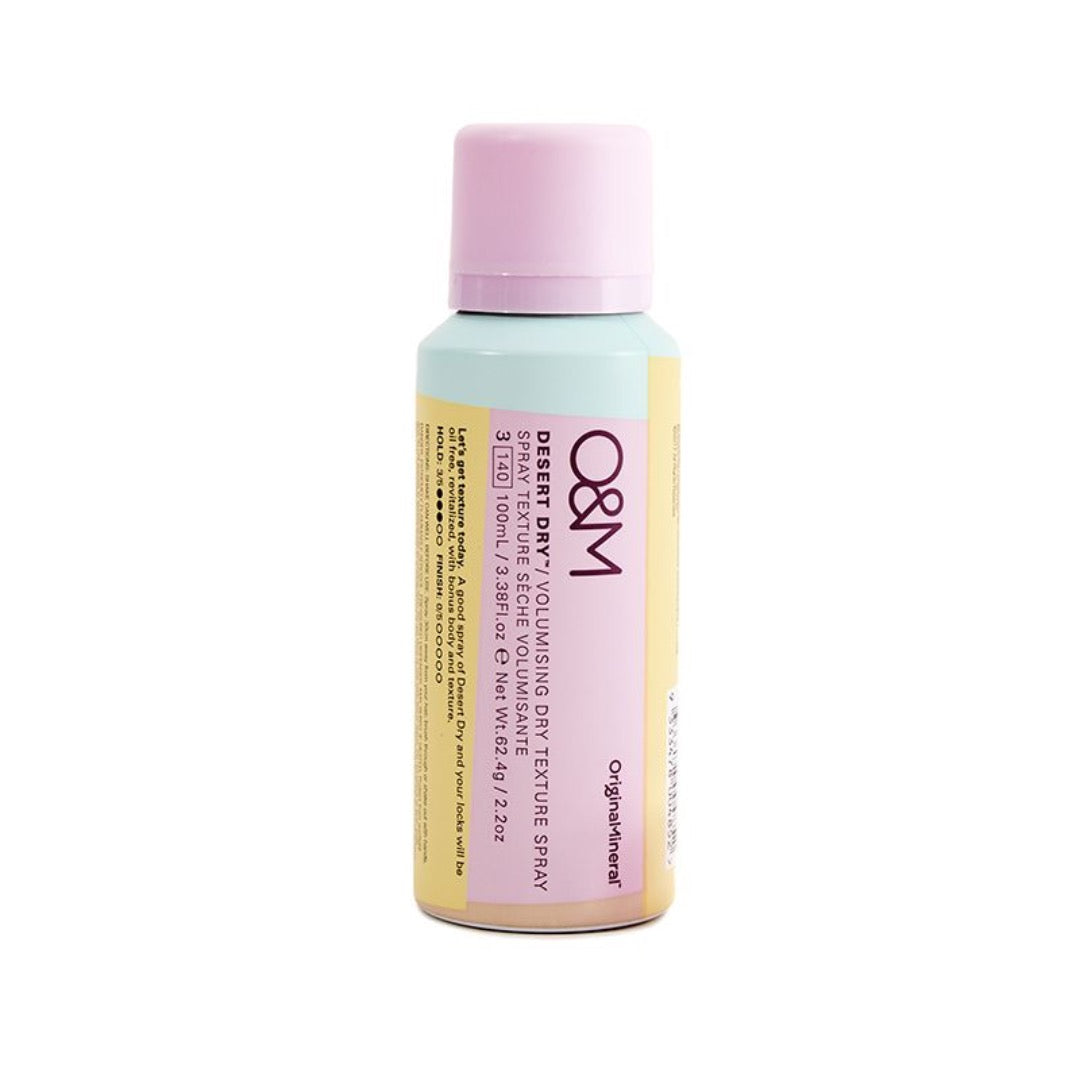 O&M Desert Dry Texture Spray in a pastel blue and yellow can with a light purple cap, labeled for lift and volume, featuring nourishing ingredients like Lilly Pilly and Quandong.