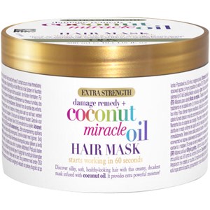 Round, gold-lidded container of OGX Extra Strength Coconut Miracle Oil Hair Mask, featuring a colorful label with text highlighting its benefits and 300ml capacity.