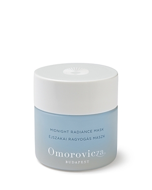 Light blue glass jar with a white lid, labeled "Midnight Radiance Mask" by Omorovicza, featuring elegant typography and a decorative emblem on top.