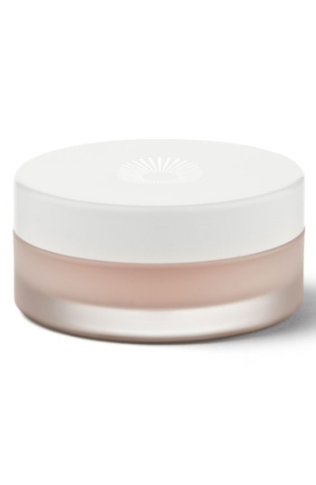 Round, frosted glass jar with a white lid, containing a light pink lip balm, featuring the Omorovicza logo embossed on the top.