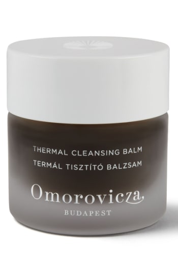Dark glass jar with a white lid, labeled "Omorovicza Thermal Cleansing Balm," featuring elegant typography and a subtle design, containing 15 ml of product.