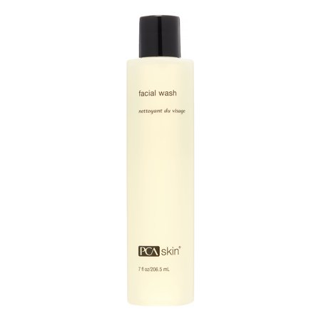 Tall, slender bottle of PCA Skin Facial Wash, featuring a pale yellow liquid, minimalist design, black text, and a capacity of 7 fl oz (206.5 mL).