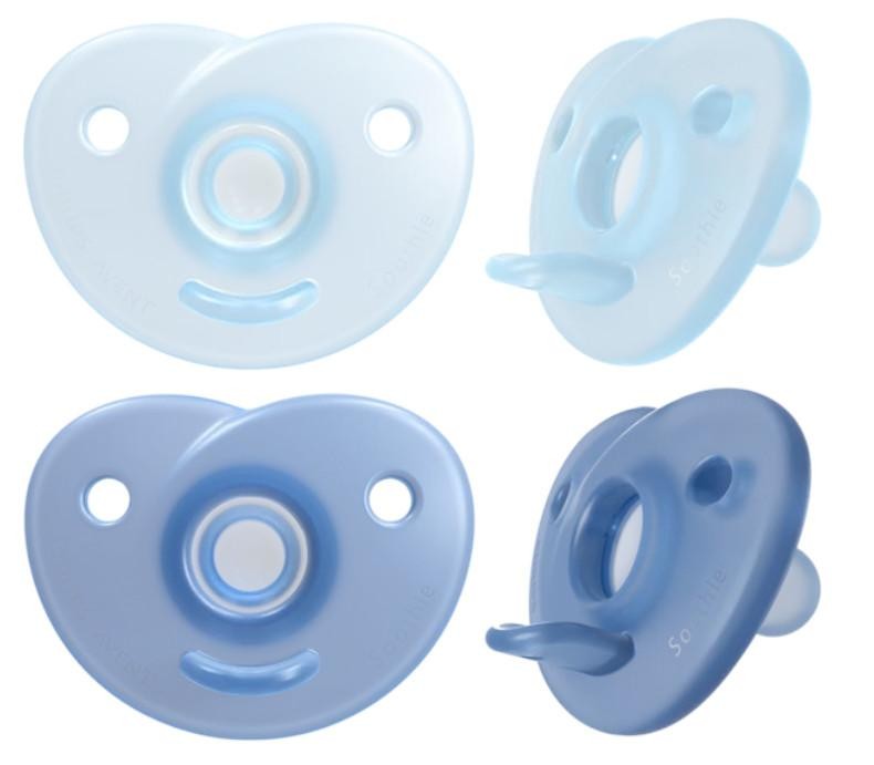 Two packs of Philips Avent pacifiers in soft blue and light blue colors, made of silicone, designed for infants aged 0-6 months, featuring a heart shape and ventilation holes.