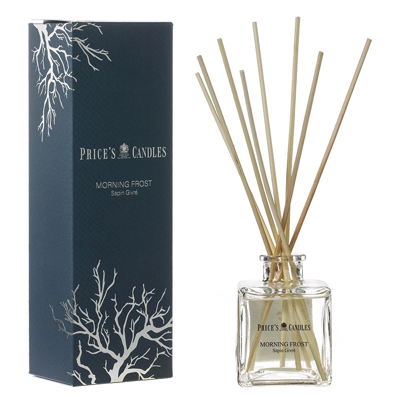 Luxury reed diffuser in a clear glass bottle with wooden reeds, featuring a dark blue box adorned with white tree branch designs, labeled "Morning Frost."