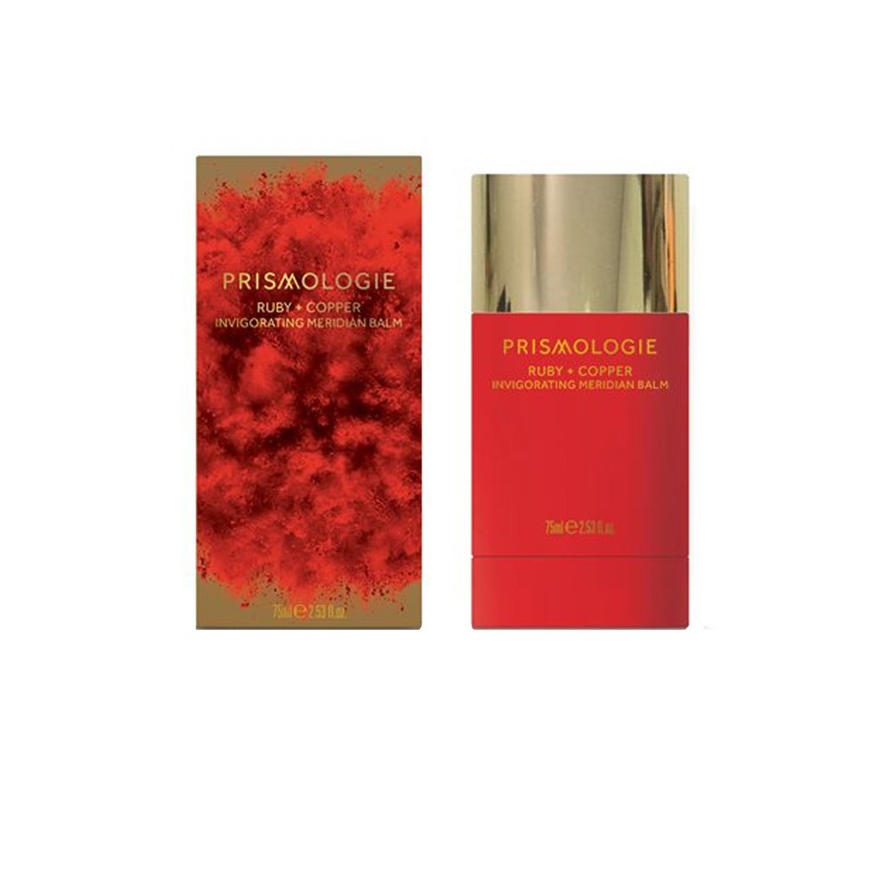 Bright red cylindrical balm container with a gold cap, accompanied by a matching red box featuring a textured design, both labeled "Prismologie Invigorating Meridian Balm Ruby & Copper."