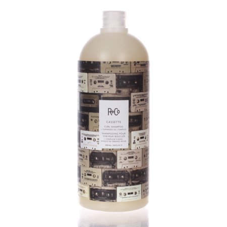 R+Co Cassette Curl Shampoo in a 33.8oz bottle features a cream-colored body with a retro cassette tape design in black and beige, showcasing its unique branding and style.