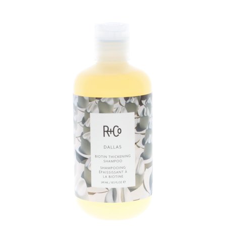 R+Co Dallas Biotin Thickening Shampoo in an 8.5 Fl. Oz. transparent bottle featuring a light yellow liquid and a decorative label with a floral design.