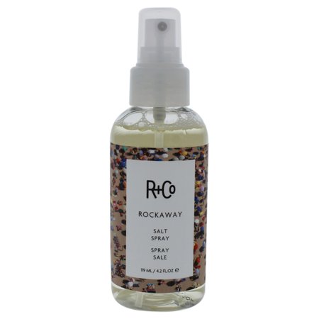 Clear spray bottle with a white label reading "R+Co Rockaway Salt Spray," featuring a colorful, speckled design; contains 124ml of hair spray for antioxidant protection.