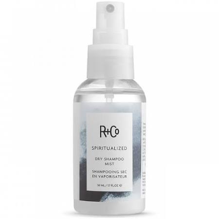 Clear plastic spray bottle with a white cap, featuring a label with a blue watercolor design, labeled "R+Co Spiritualized Dry Shampoo Mist," 1.7 Fl. Oz.