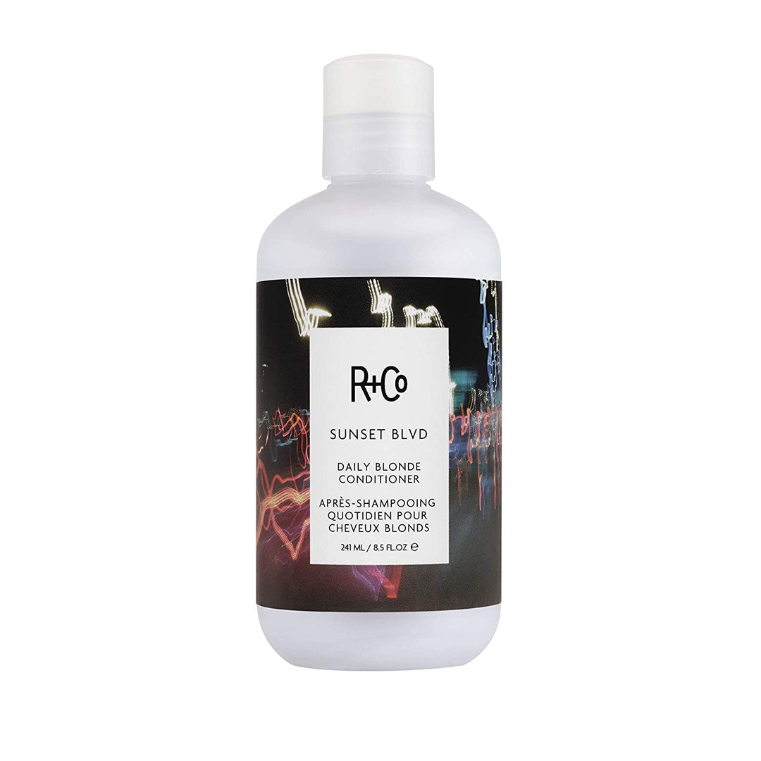 White bottle of R+Co Sunset Blvd Daily Blonde Conditioner, 241ml, featuring a colorful abstract label with the brand name and product details prominently displayed.