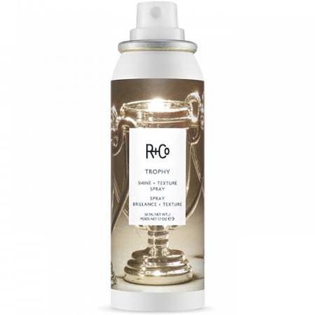 R+Co TROPHY SHINE & TEXTURE SPRAY in a sleek white and silver canister, featuring a trophy graphic and a black label, designed for unisex use, 1.7 oz size.