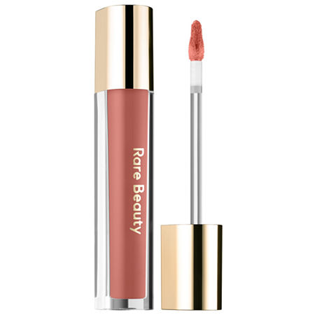 Glossy lip balm in a clear tube with a gold cap, featuring a soft, nearly neutral pink shade and a doe-foot applicator for easy application.