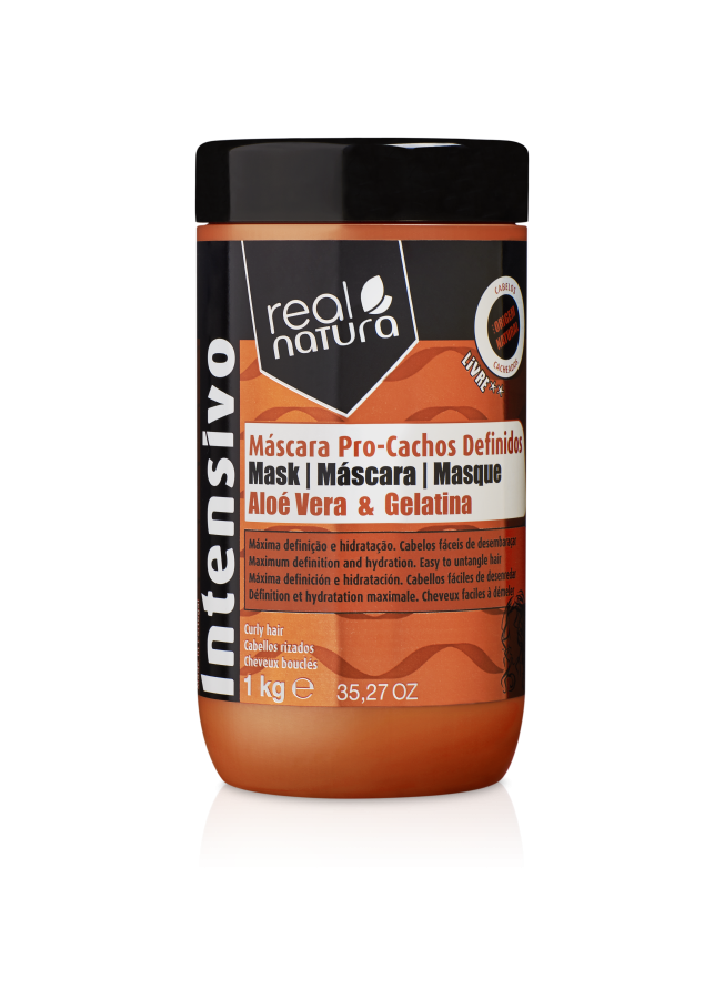 Black jar with an orange lid, labeled "Real Natura 1000 G" and "Máscara Pro-Cachos Definido," featuring aloe vera and gelatin for curly hair care.