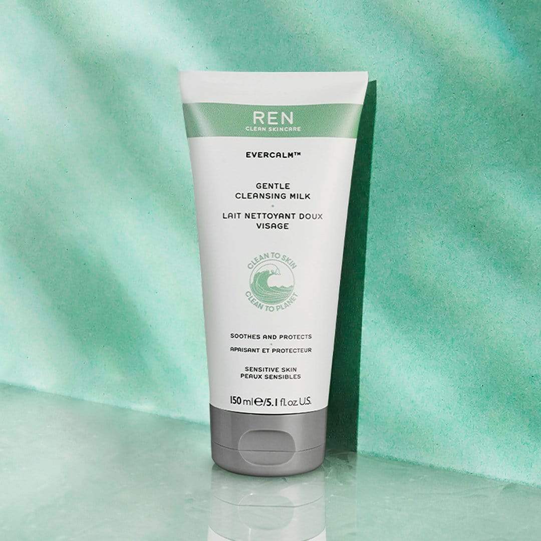 White tube with green accents, labeled "REN Evercalm Gentle Cleansing Milk," 150ml, designed for sensitive skin, featuring a clean, minimalist aesthetic against a soft green background.