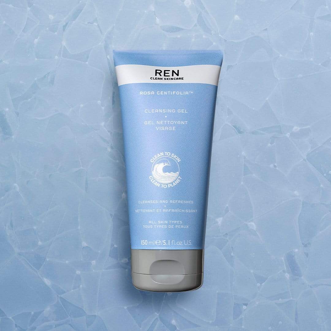 Light blue tube of REN Skincare Rosa Centifolia Cleansing Gel with a white cap, featuring a minimalist design and text detailing its cleansing properties, set against a textured background.