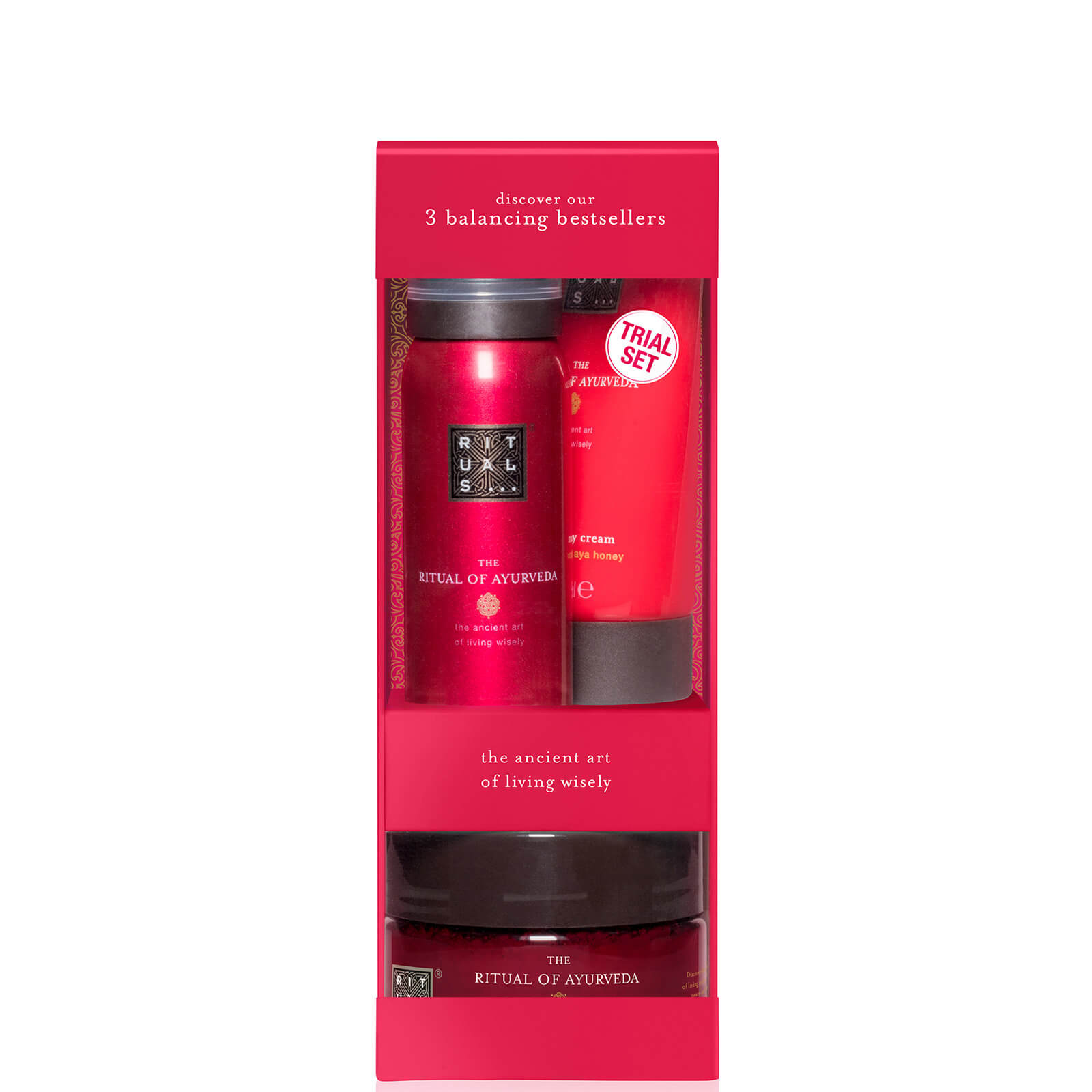 Bright pink gift box featuring Rituals' Ayurveda set, including a 70ml body cream, 125g body scrub, and 50ml foaming shower gel, all elegantly packaged with black and white labels.