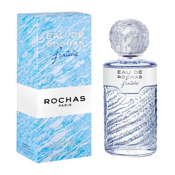 Clear glass bottle with a textured wave design, topped with a round, frosted cap, alongside a light blue box featuring the Rochas logo and product name in elegant typography.