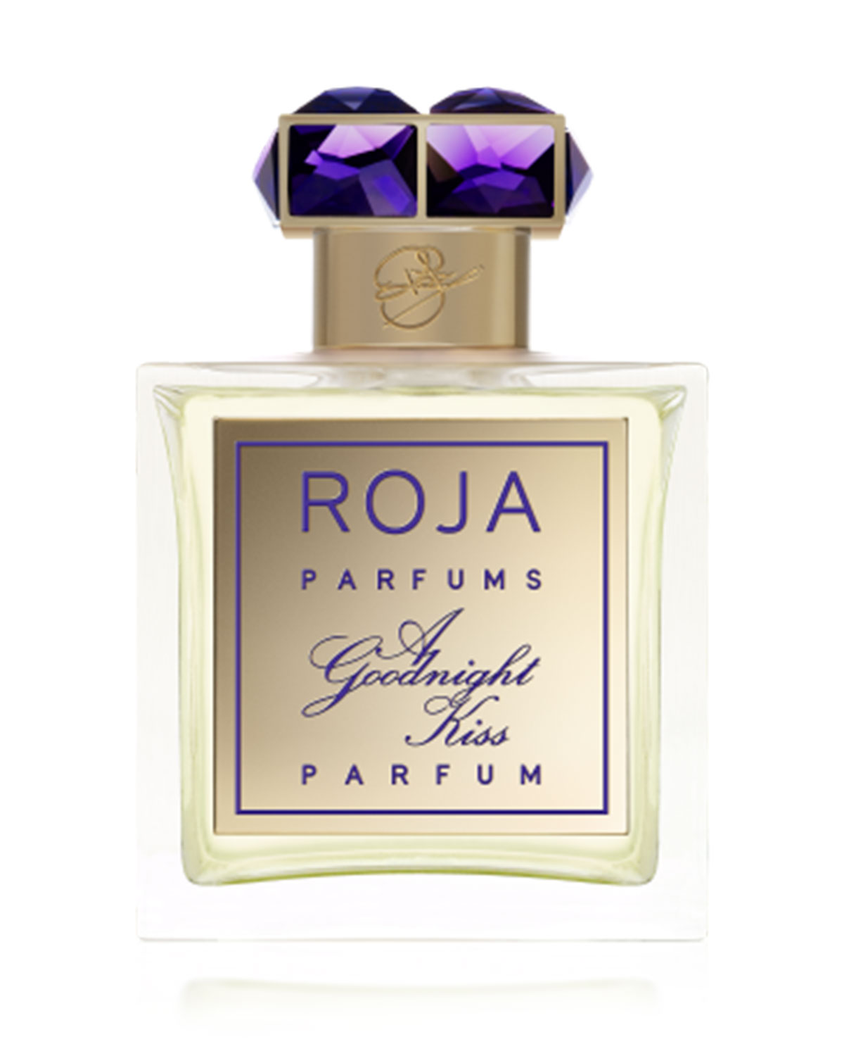 Clear glass perfume bottle with a gold label reading "ROJA PARFUMS A Goodnight Kiss," topped with a decorative purple cap featuring two faceted gems.
