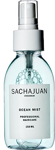 Clear plastic spray bottle with a white label, featuring black text that reads "SACHAJUAN OCEAN MIST PROFESSIONAL HAIRCARE," containing a light blue liquid.