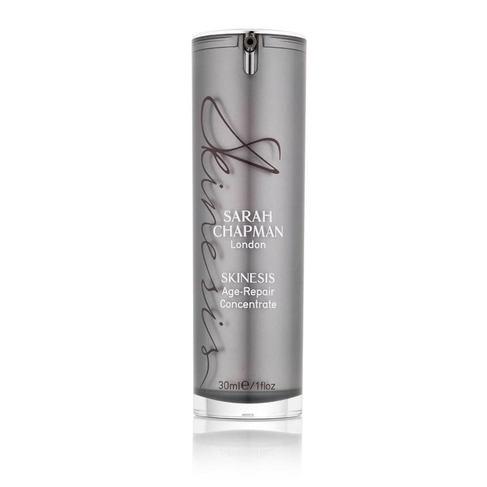 Silver cylindrical bottle with a sleek design, featuring the text "Sarah Chapman Skinesis Age Repair Concentrate" in elegant font, 30ml size, with a pump top.