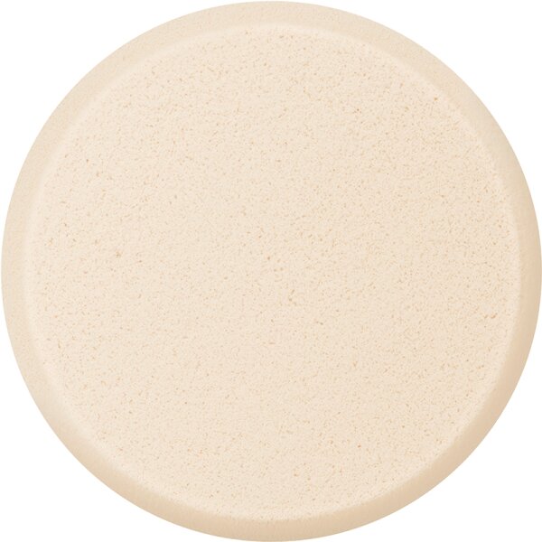 Round, soft foundation sponge in a light beige color, featuring a smooth surface and slightly raised edges for easy application of makeup.