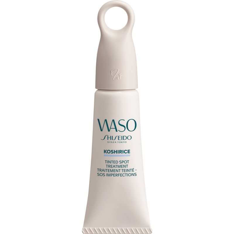 A soft peach-colored tube with a twist cap, labeled "WASO Koshirice Tinted Spot Treatment" in teal lettering, featuring a minimalist design and a small handle on top.