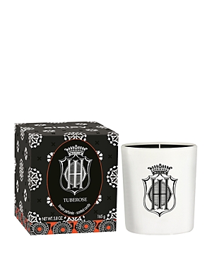 White ceramic candle with a black logo, accompanied by a decorative black and white patterned box featuring a floral design, labeled "Tuberose."