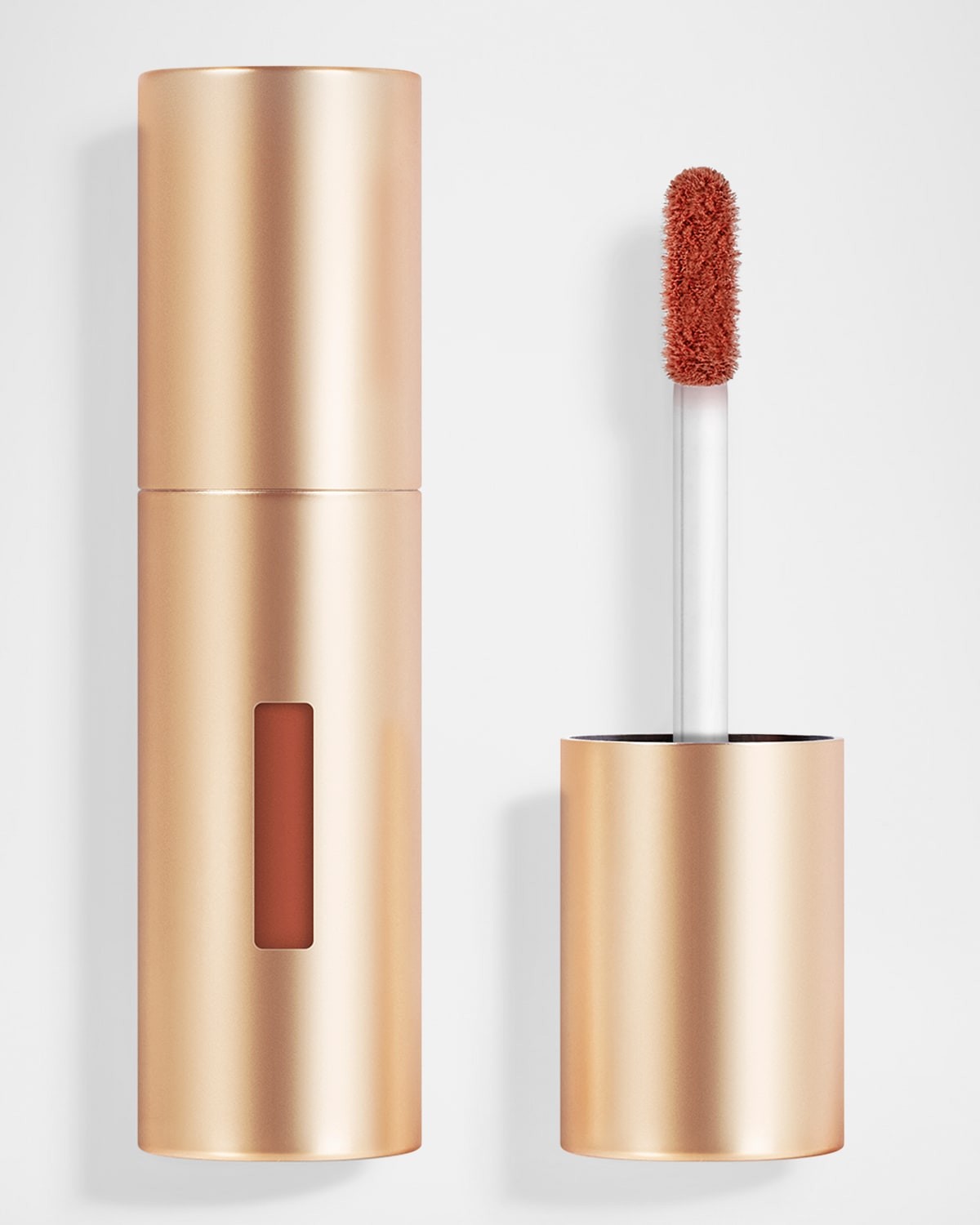 Gold metallic lipstick and blush tube with a clear window, featuring a soft, fluffy applicator wand and a warm, reddish-brown shade inside.