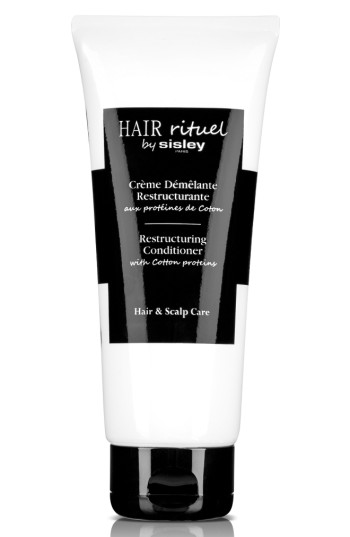 White tube with a black label, featuring the text "Hair Rituel by Sisley" and "Restructuring Conditioner with Cotton Proteins," designed for hair and scalp care.