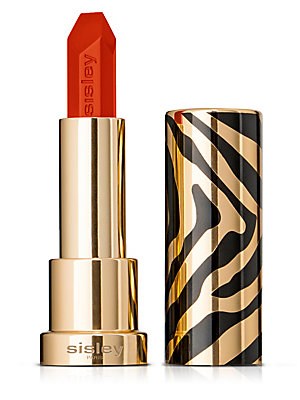 Bright orange lipstick in a sleek gold and black zebra-striped case, featuring the Sisley Paris logo on the base.
