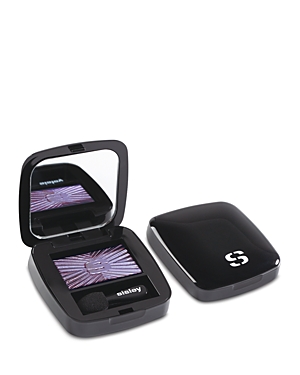 Black compact eyeshadow case with a mirror, featuring a sparkling purple eyeshadow inside, accompanied by a small applicator. The lid displays the Sisley logo.