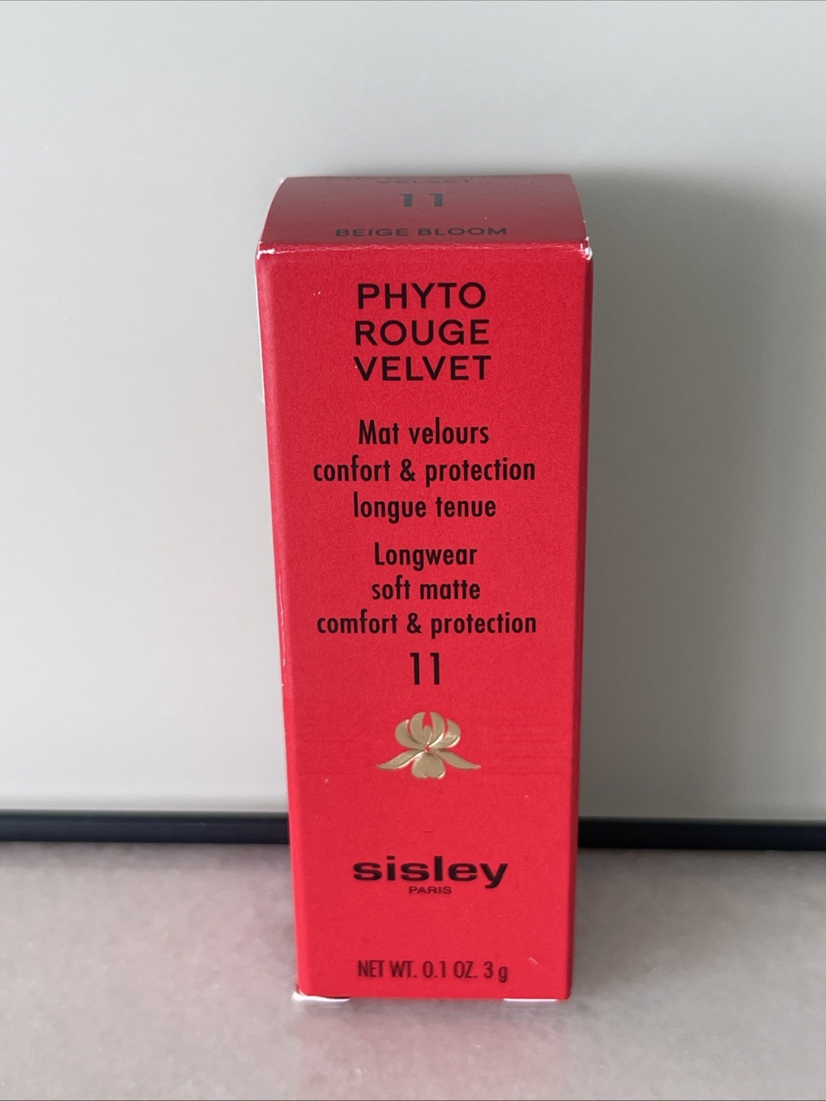 Red packaging with a glossy finish, featuring "Phyto-Rouge Velvet" and "Beige Bloom" in elegant typography, alongside a floral logo and Sisley branding.